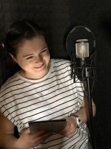 Smiling Eurasian woman in a recording Studio.